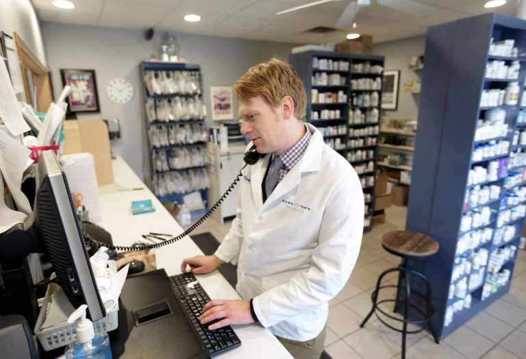 Ryan Bender, Pharmacist at Hometown Pharmacy in Rio taking prescription orders.