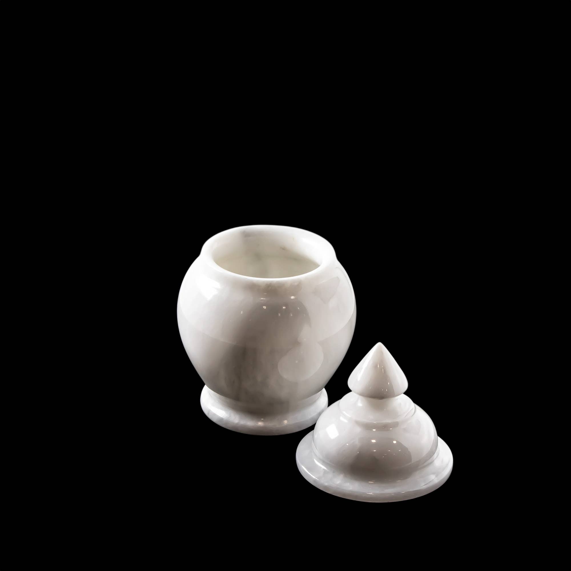 White marble urn with lid, on black background.